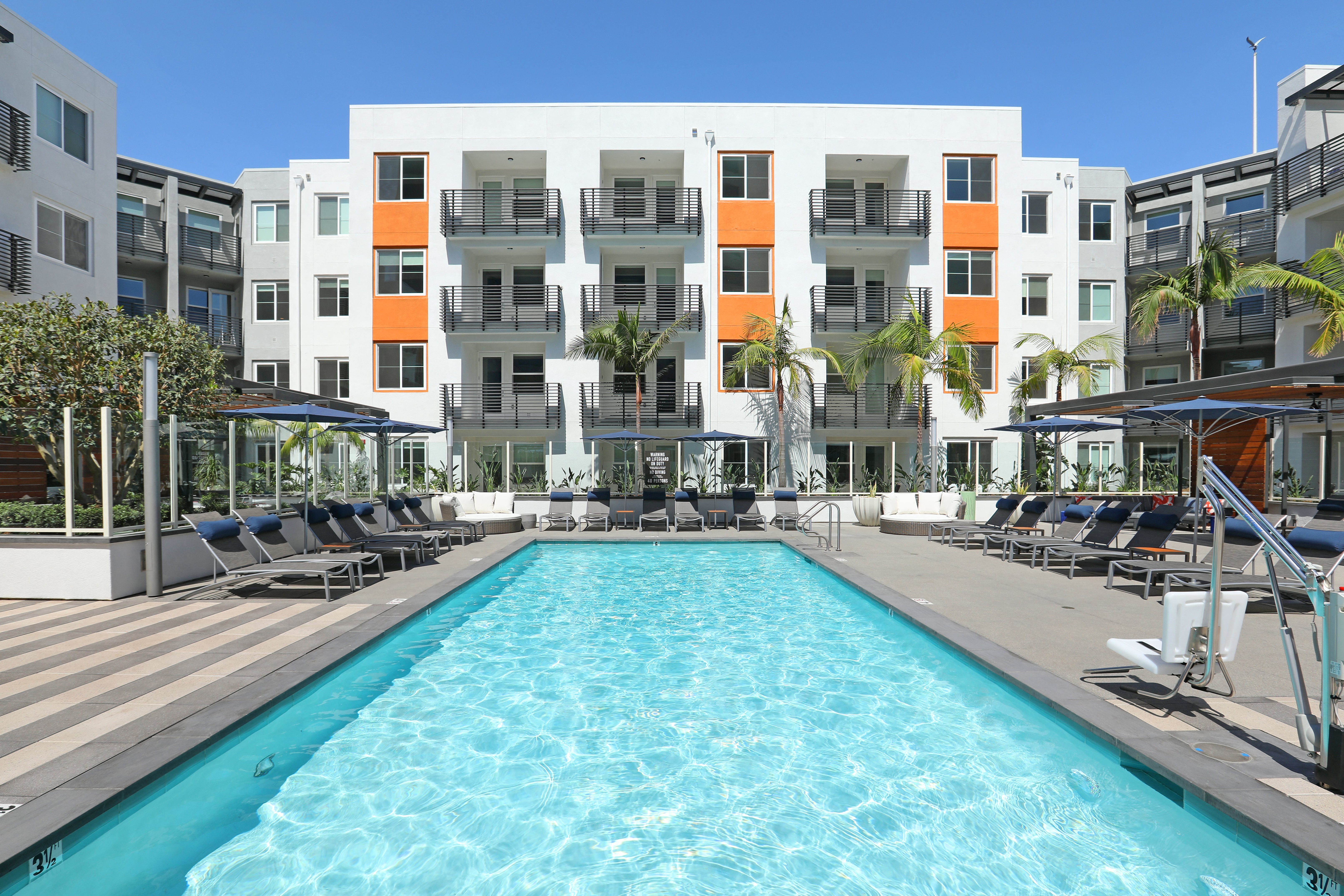 a swimming pool in front of an apartment building,a swimming pool in front of an apartment building,a swimming pool in front of an apartment building